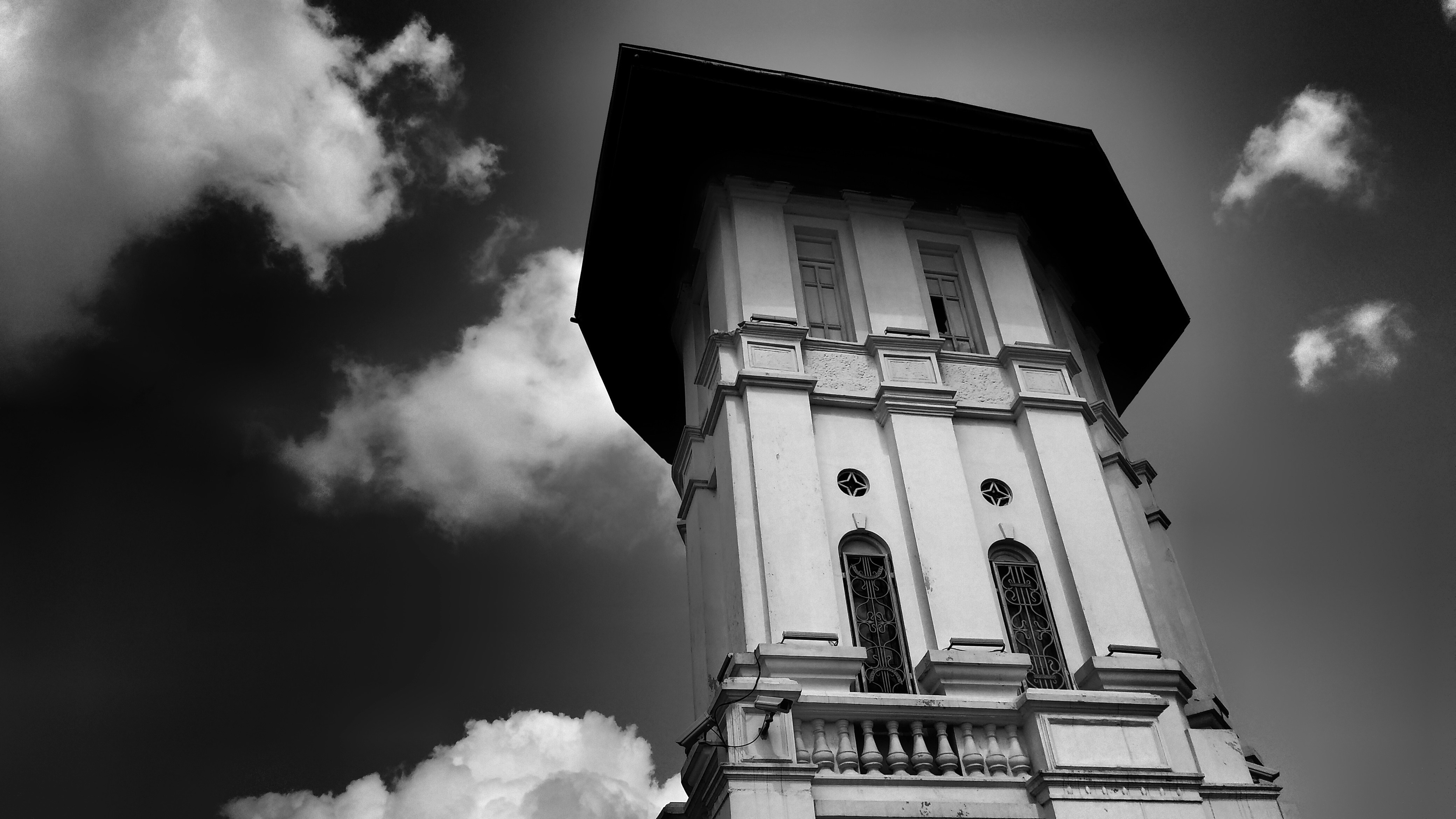 grayscale photo of concrete building under cloudy sky at daytime