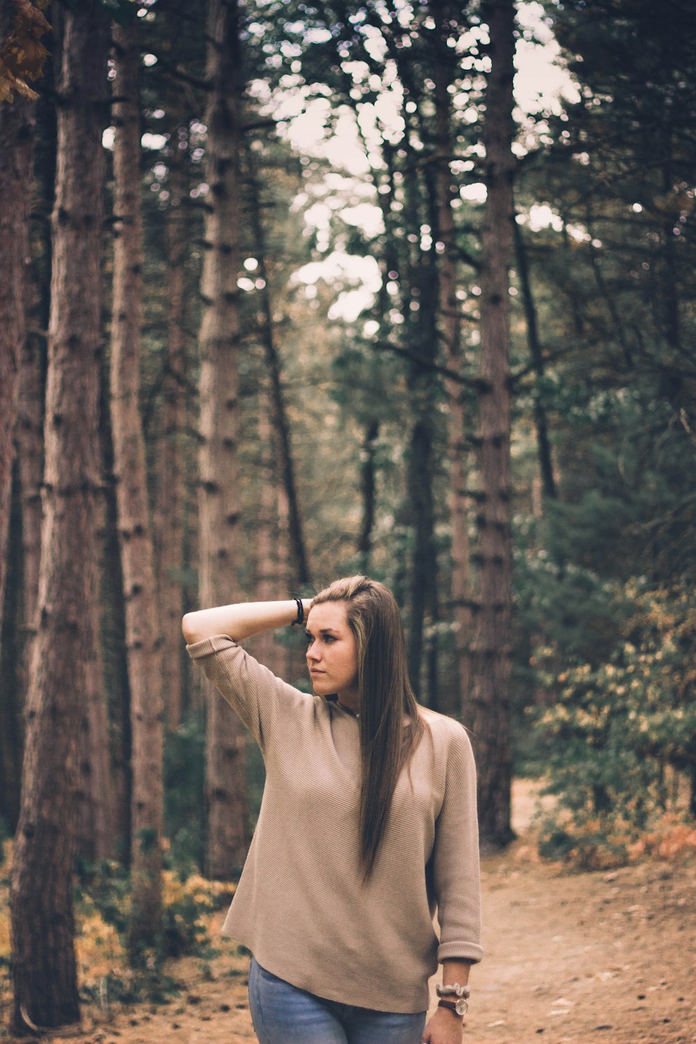 woman standing under green trees