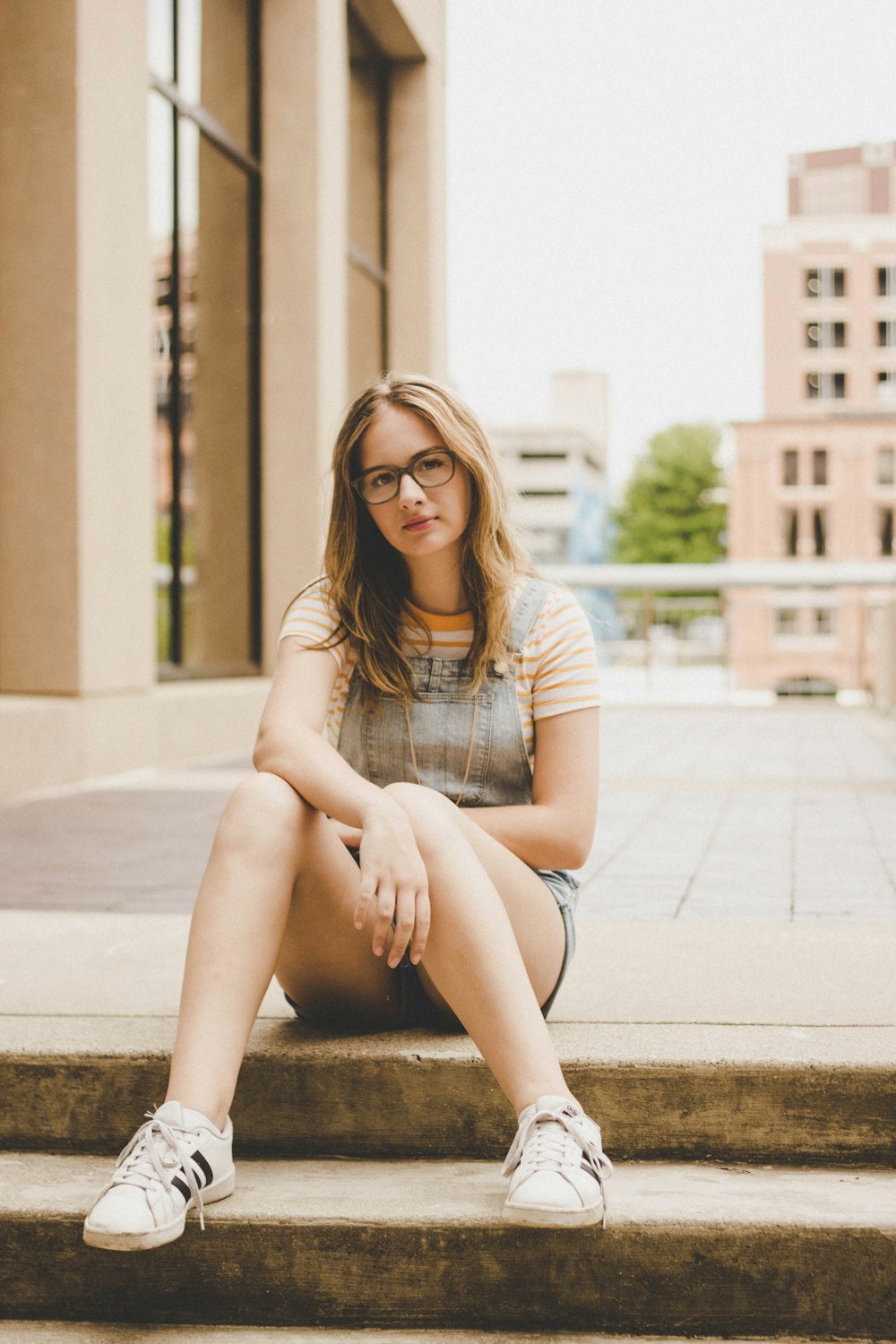 woman sitting on brown concrete stairs