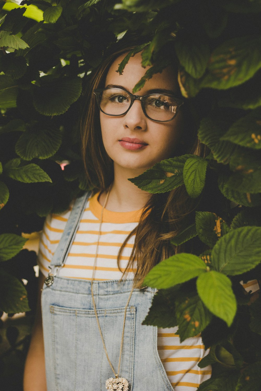 woman surrounded by green-leafed plants