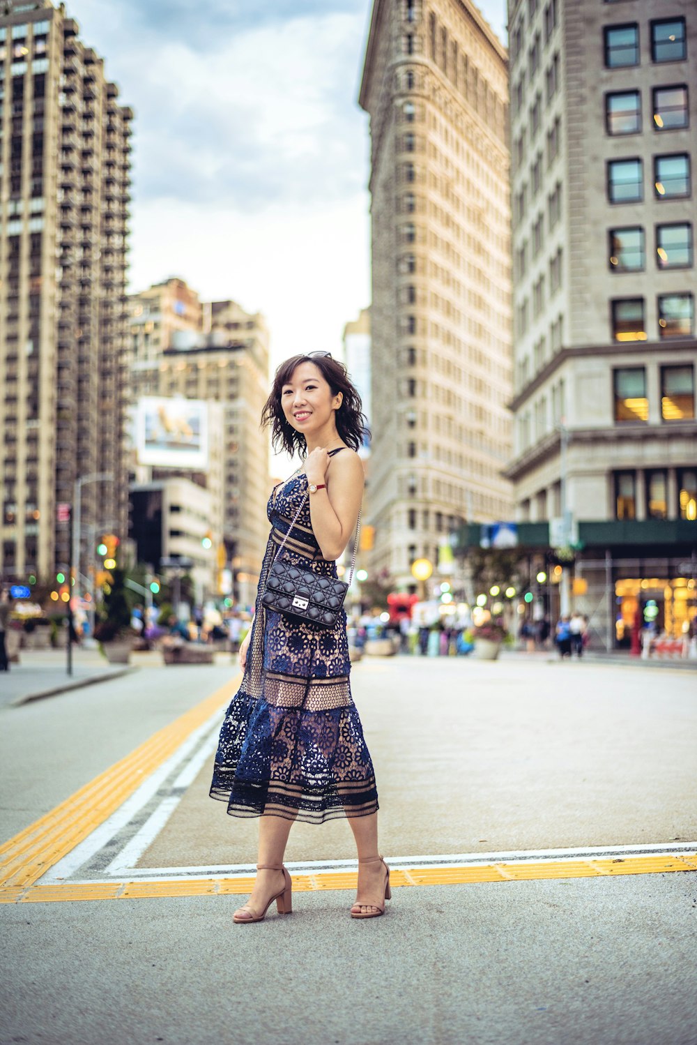 woman standing in center of street near buildings