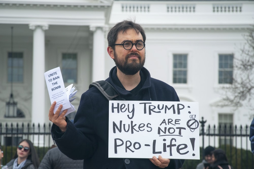 man holding white signage