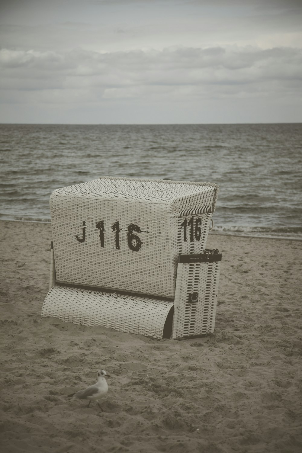 cesto di vimini bianco numerato 116 sulla spiaggia