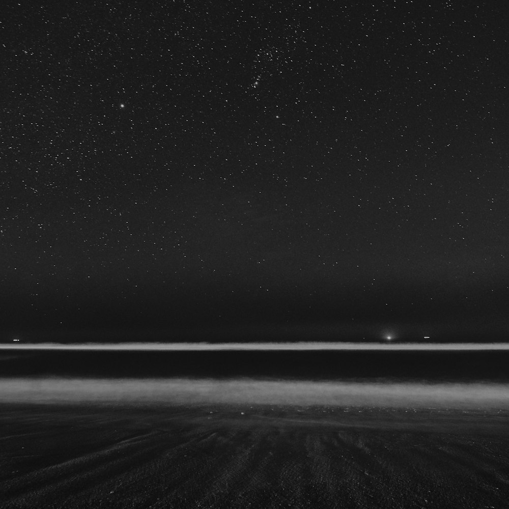 fotografia in scala di grigi del campo sotto le stelle