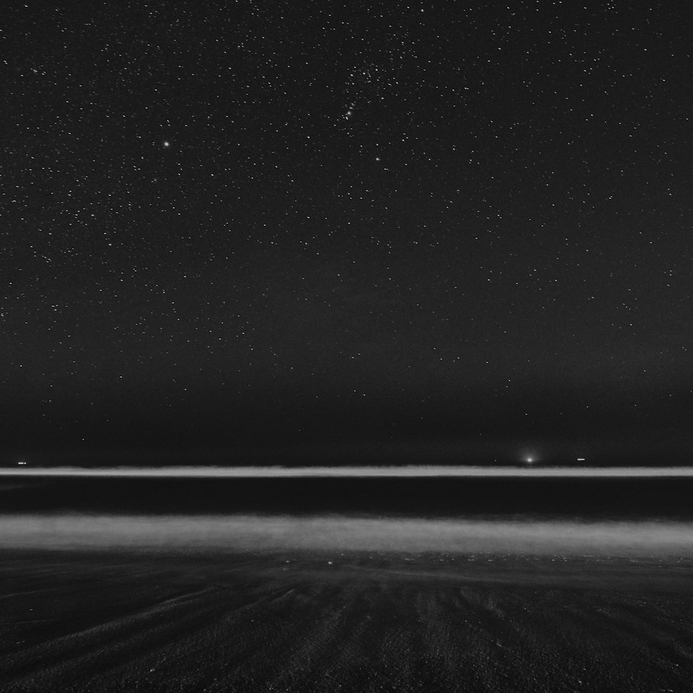 grayscale photography of field under stars