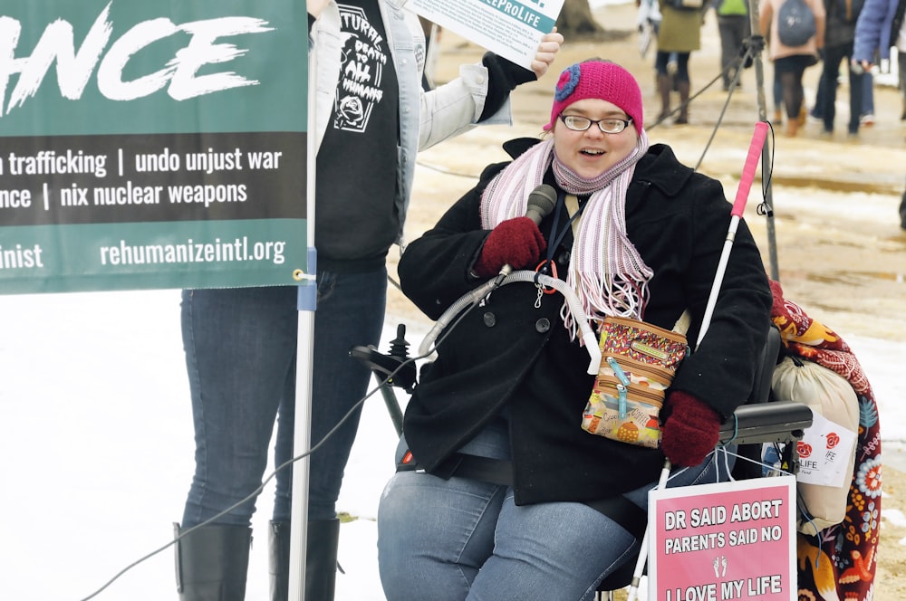 woman sitting next to signage