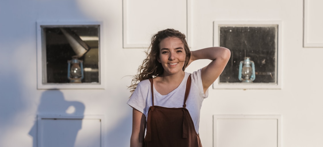 woman in white t-shirt and brown overalls