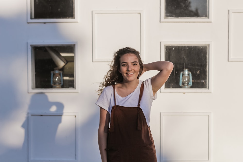 woman in white t-shirt and brown overalls