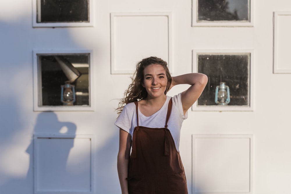 Mujer con camiseta blanca y mono marrón