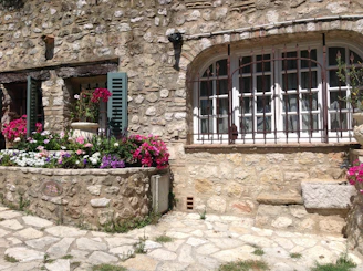 Charming village house with rustic stone walls and blooming flowers in Portet sur Garonne.