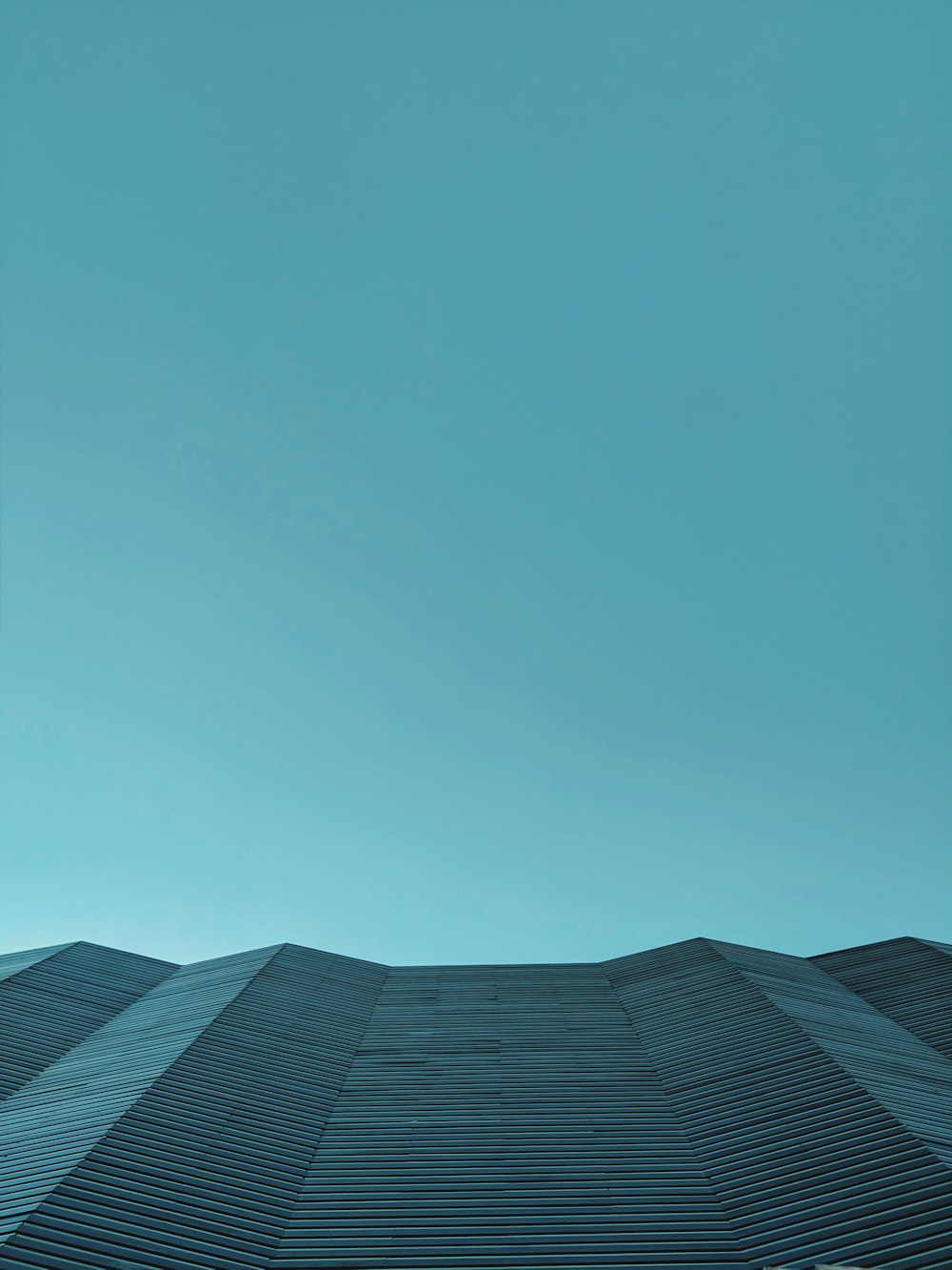 low-angle photography of gray structure under calm blue sky