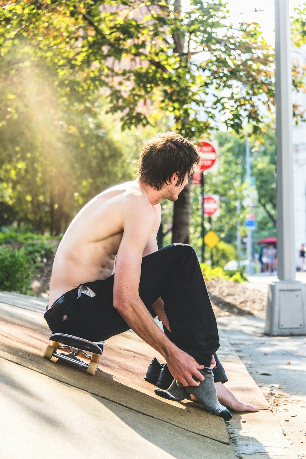 Mann sitzt auf Skateboard