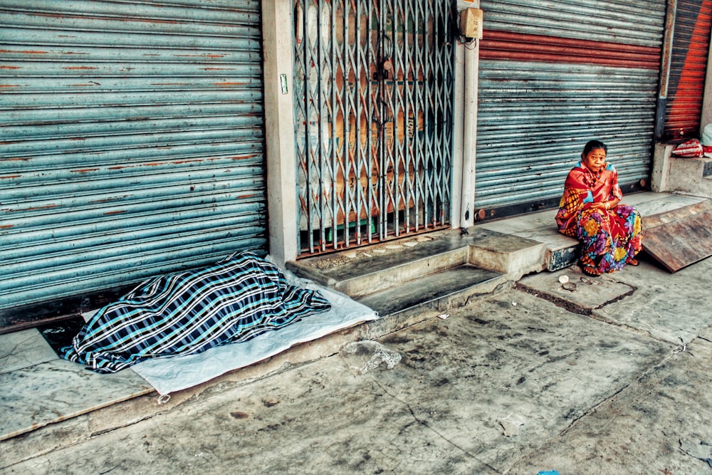 woman sitting on sidewalk