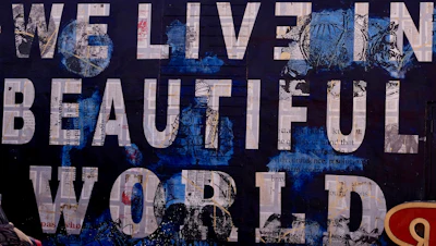 Collage lettering reading “We live in a beautiful world”
