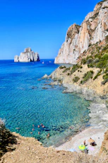 body of water near brown rock formation