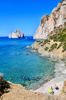 body of water near brown rock formation