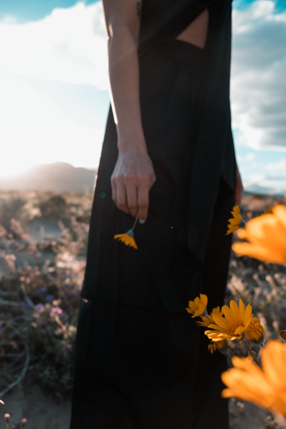 a person standing in a field with yellow flowers