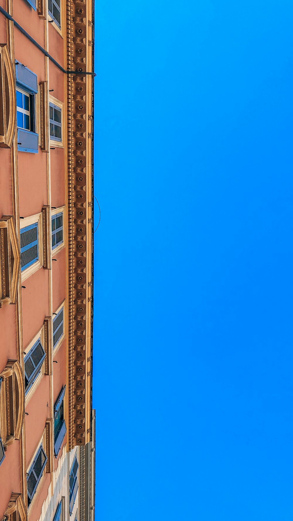 a tall building with windows and a blue sky in the background