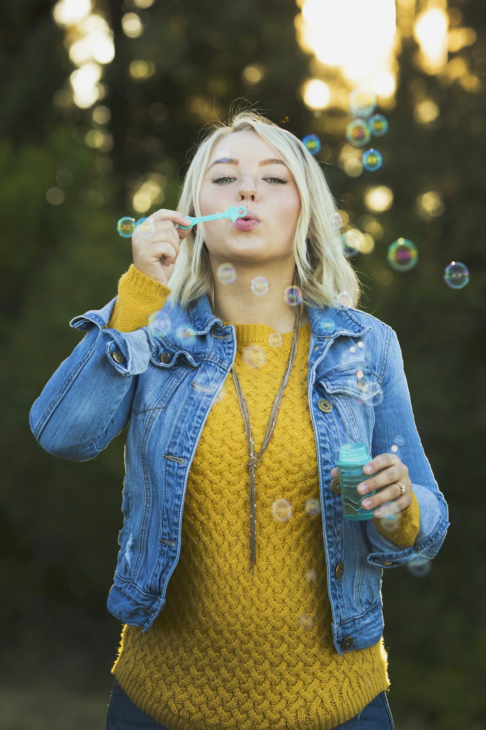 Jouet de bulles soufflant une femme pendant la journée