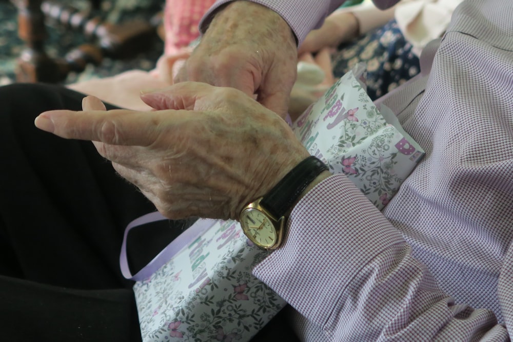 person wearing round gold-colored framed analog watch