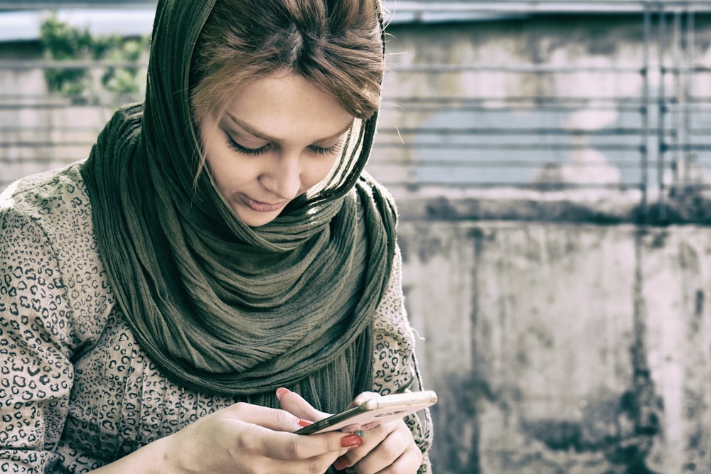 donna che tiene il telefono che indossa l'hijab nero