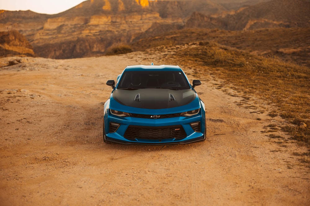 blue car parked beside rock formation