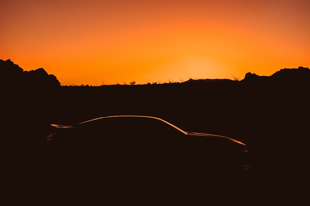 silhouette of sports car on park during sunset
