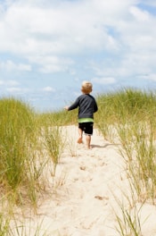 boy running on sand during daytime