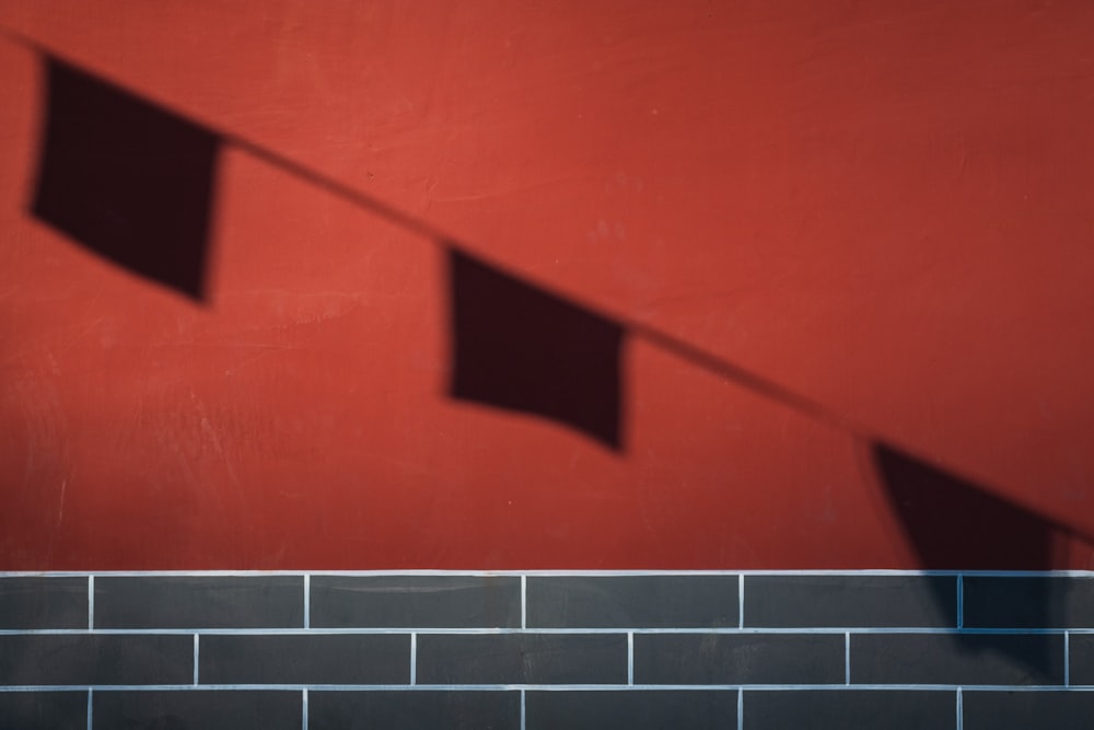 shadow of buntings on red surface