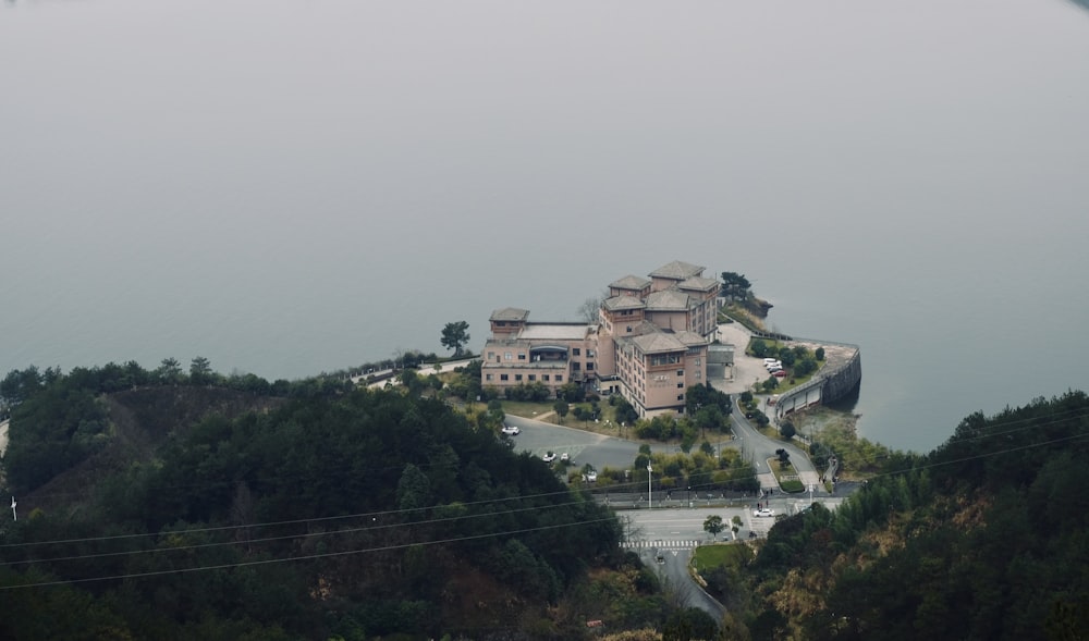 concrete buildings near green mountain at daytime