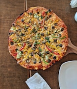 cooked pizza on brown wooden table