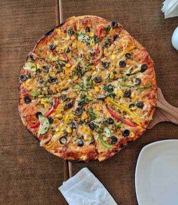 cooked pizza on brown wooden table