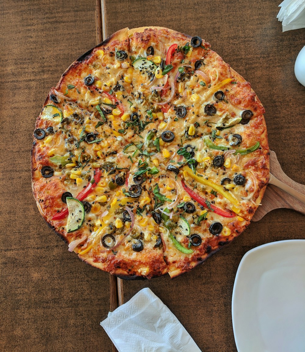 Pizza cocida en una mesa de madera marrón