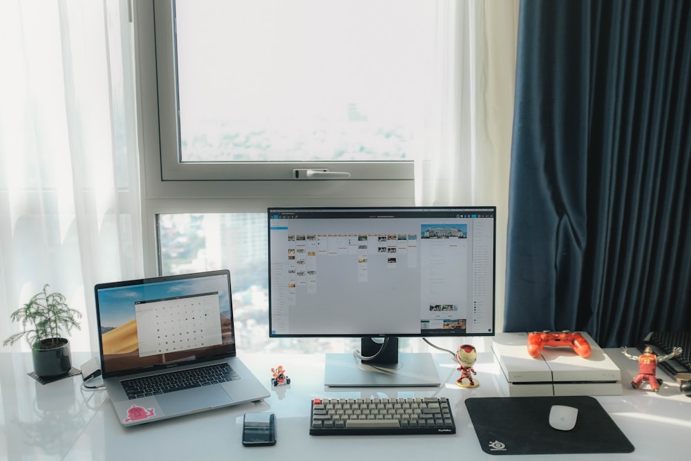 flat screen computer monitor and MacBook Pro near window