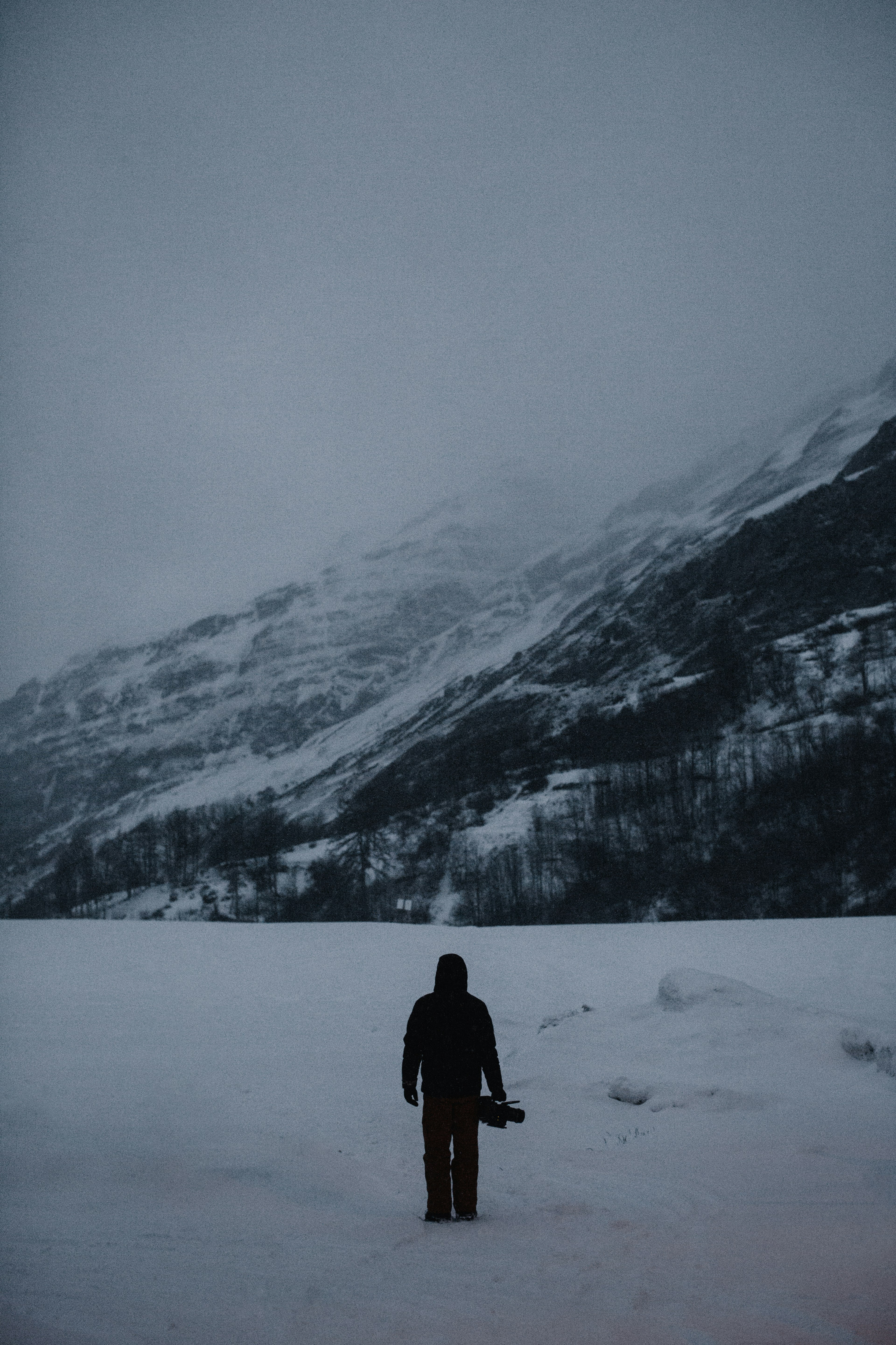 man carrying case near the mountain