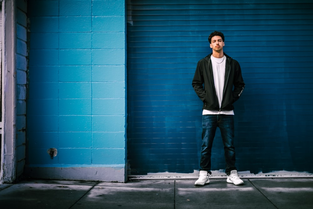 man standing in front of blue roller shutter