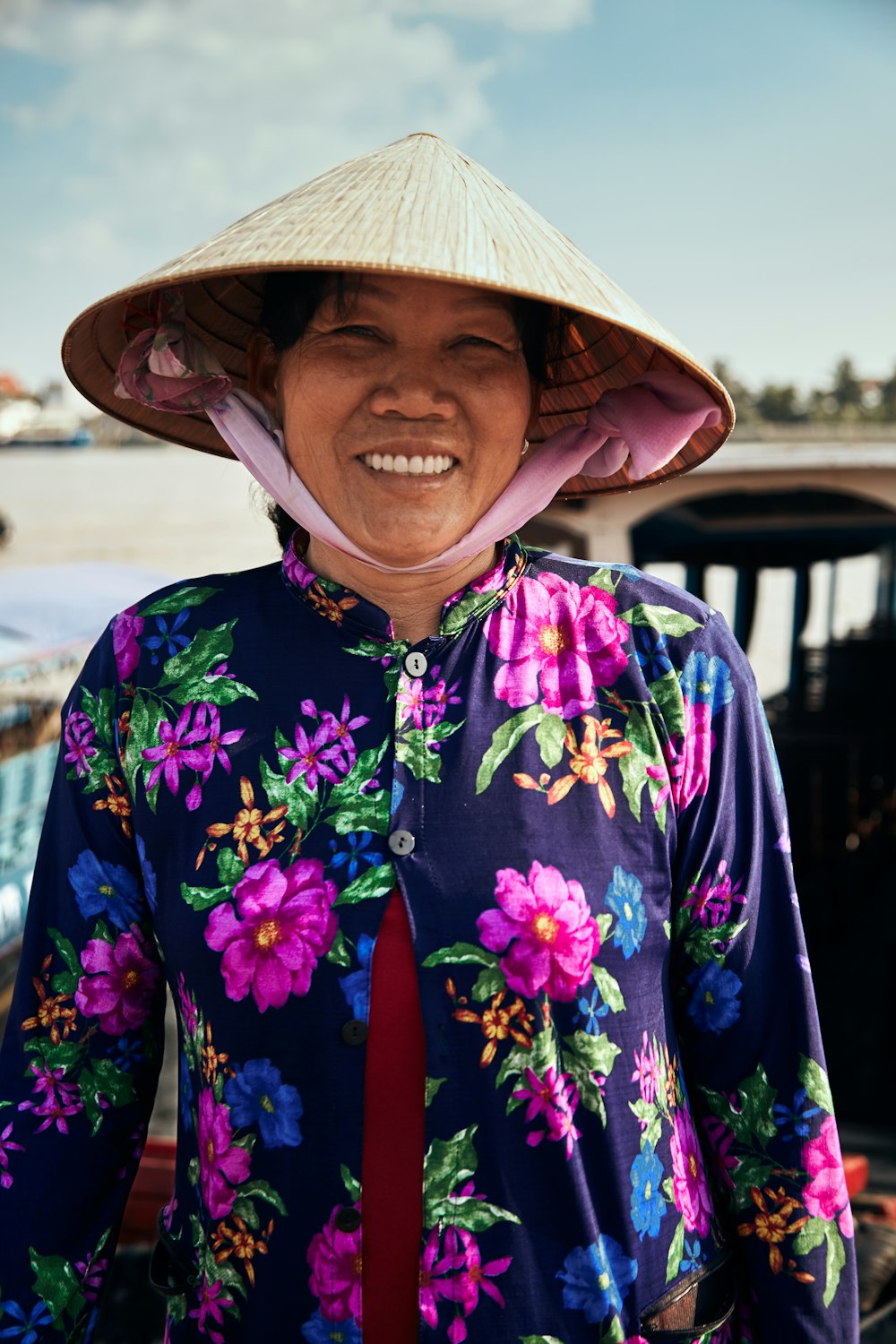 Femme en chapeau tissé et chemise à manches longues boutonnée à fleurs