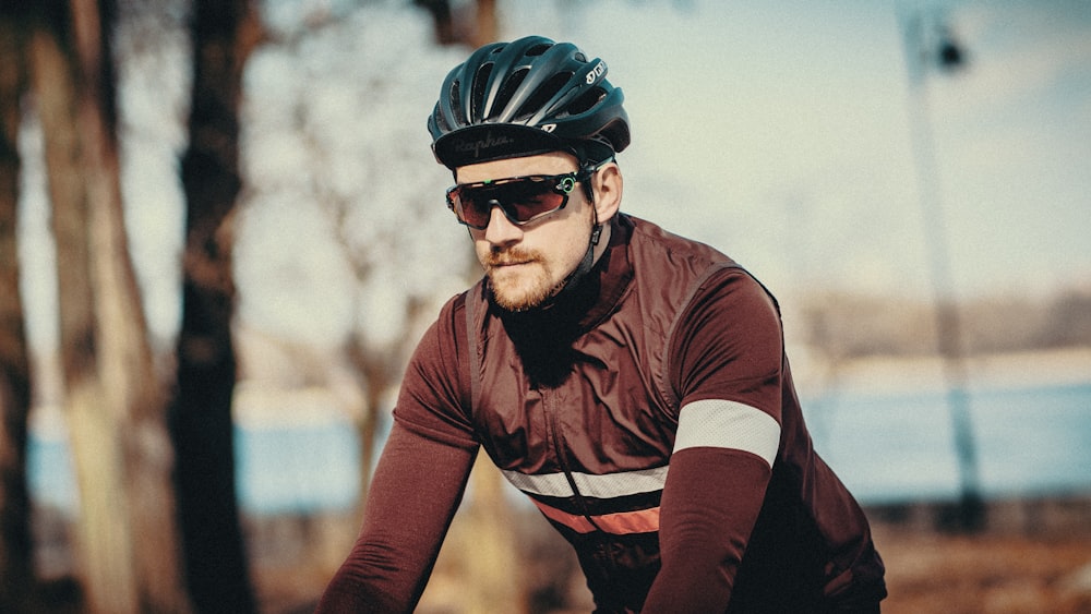 man in maroon long-sleeved shirt riding bike