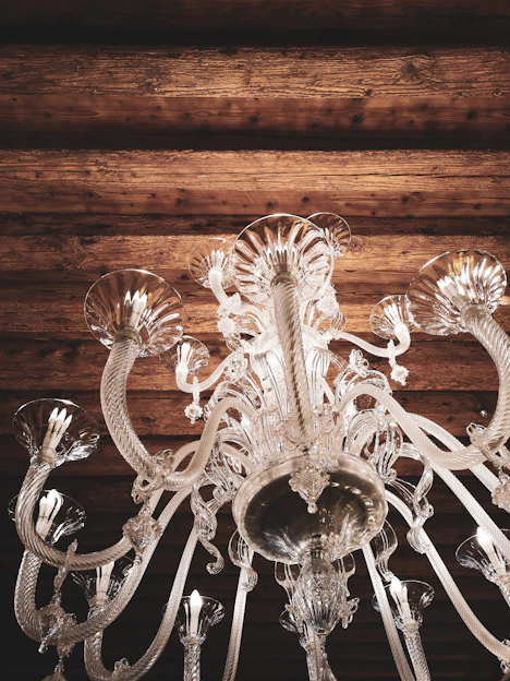A stunning crystal chandelier casting a warm glow over a stylish living room.