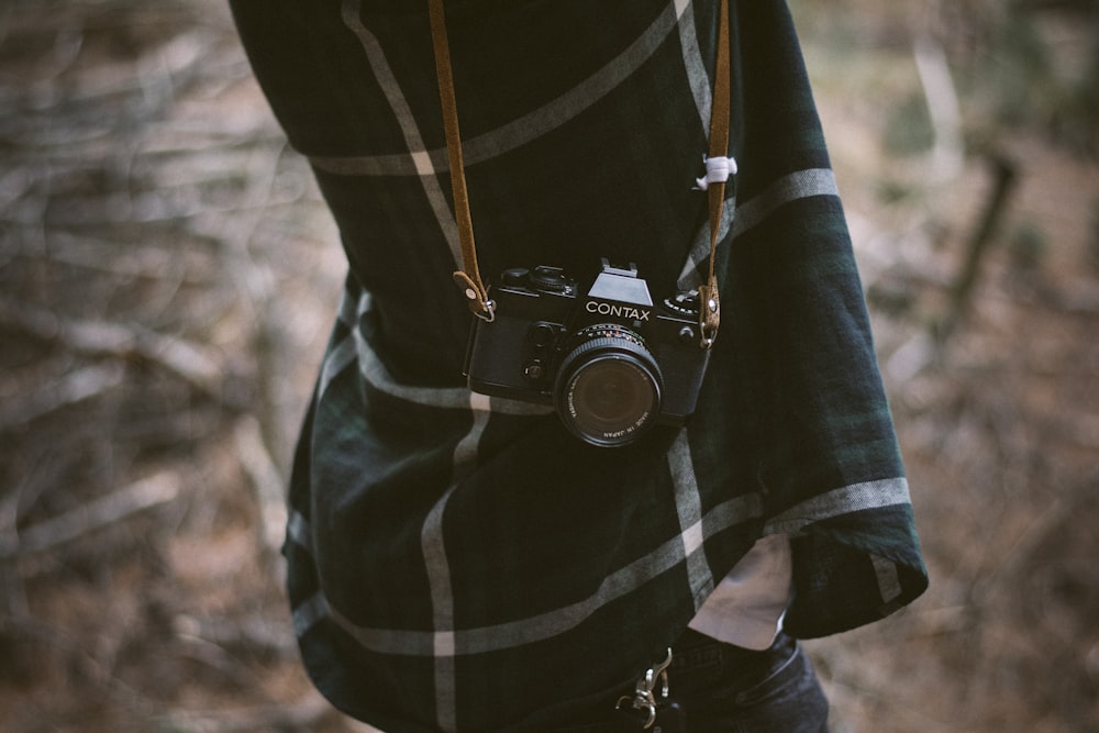 person carrying black Contax mirrorless camera