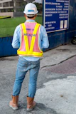 man standing near blue wooden sign