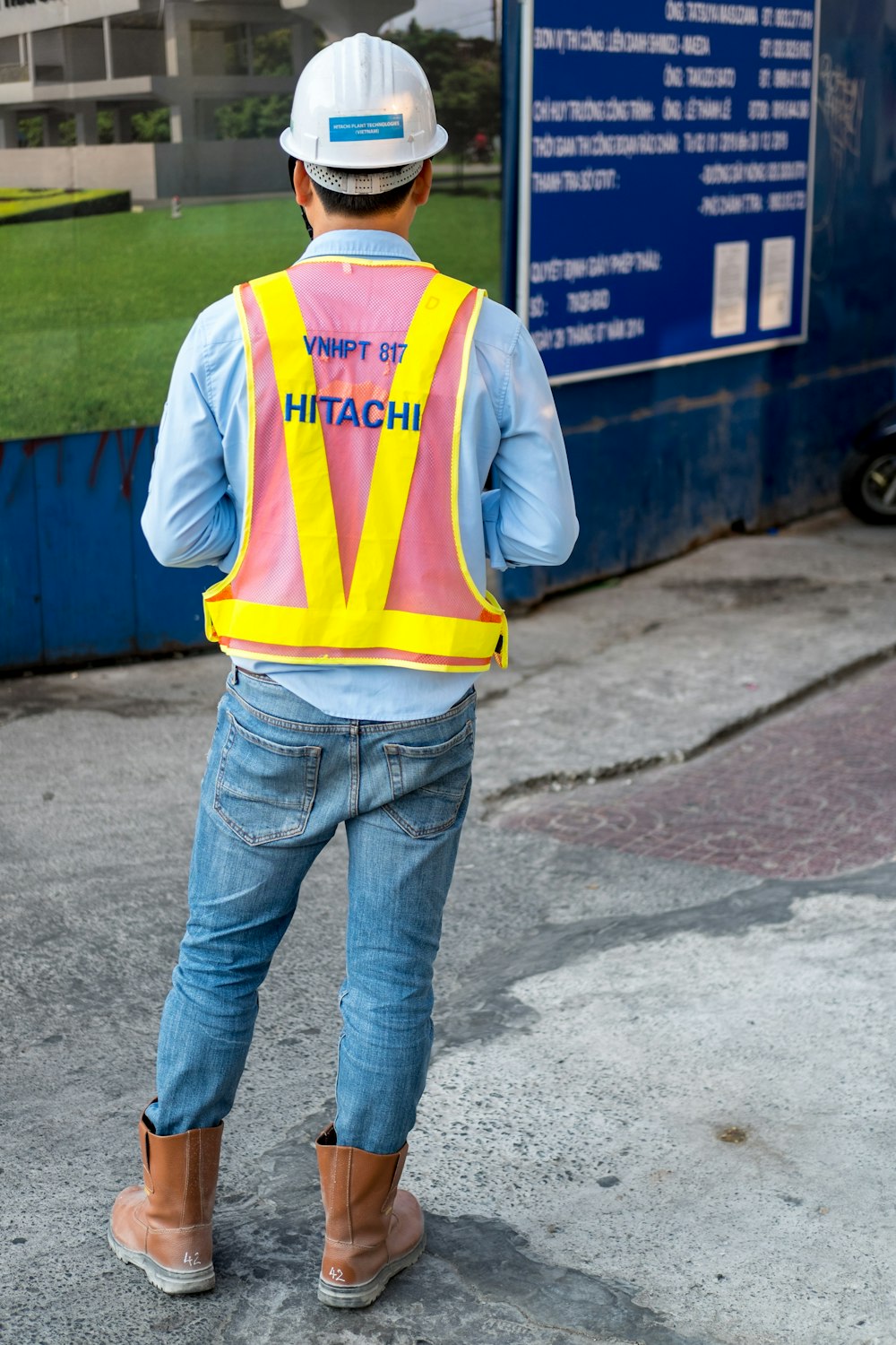 man standing near blue wooden sign