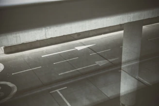 Wide shot of a road with clear white dividing lines and directional arrows.