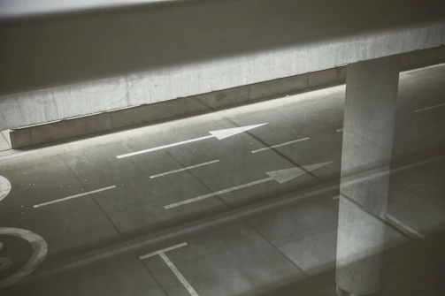 Wide shot of a road with clear white dividing lines and directional arrows.
