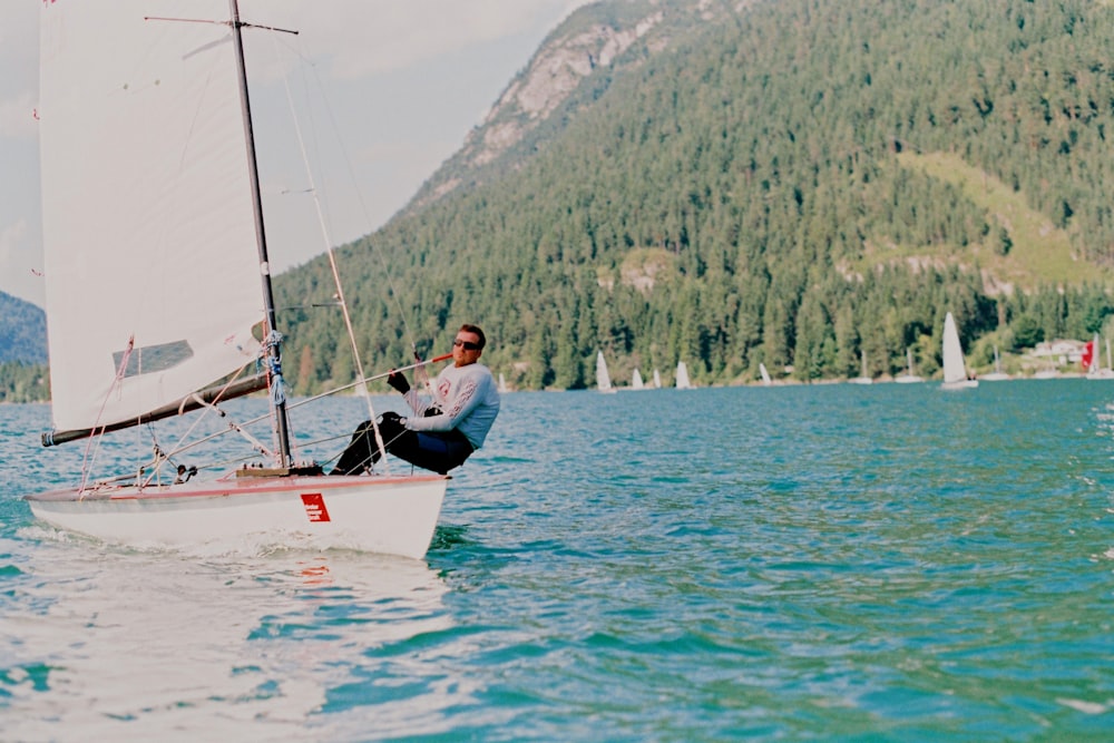 man sitting on sailboat during daytime