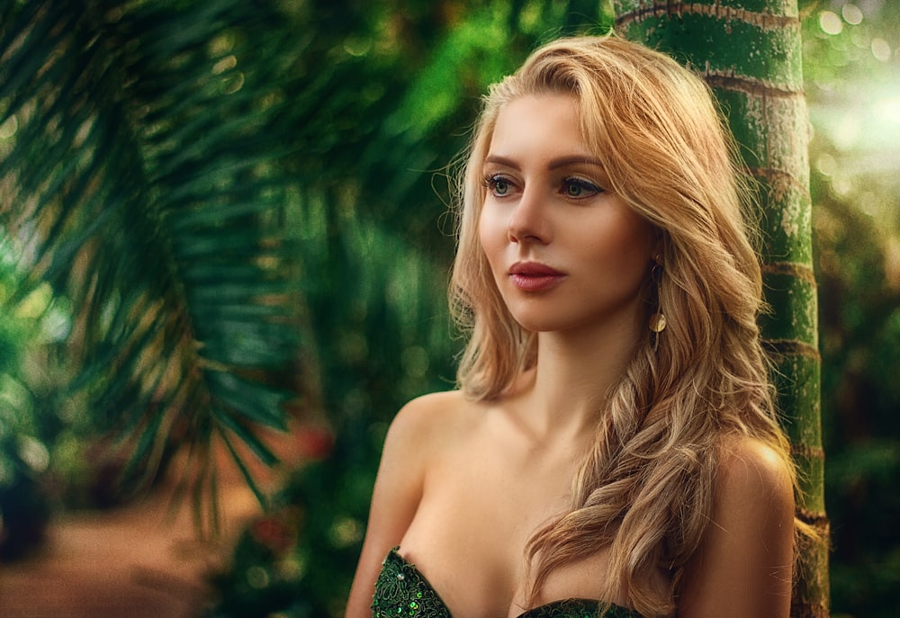 woman leaning on green tree