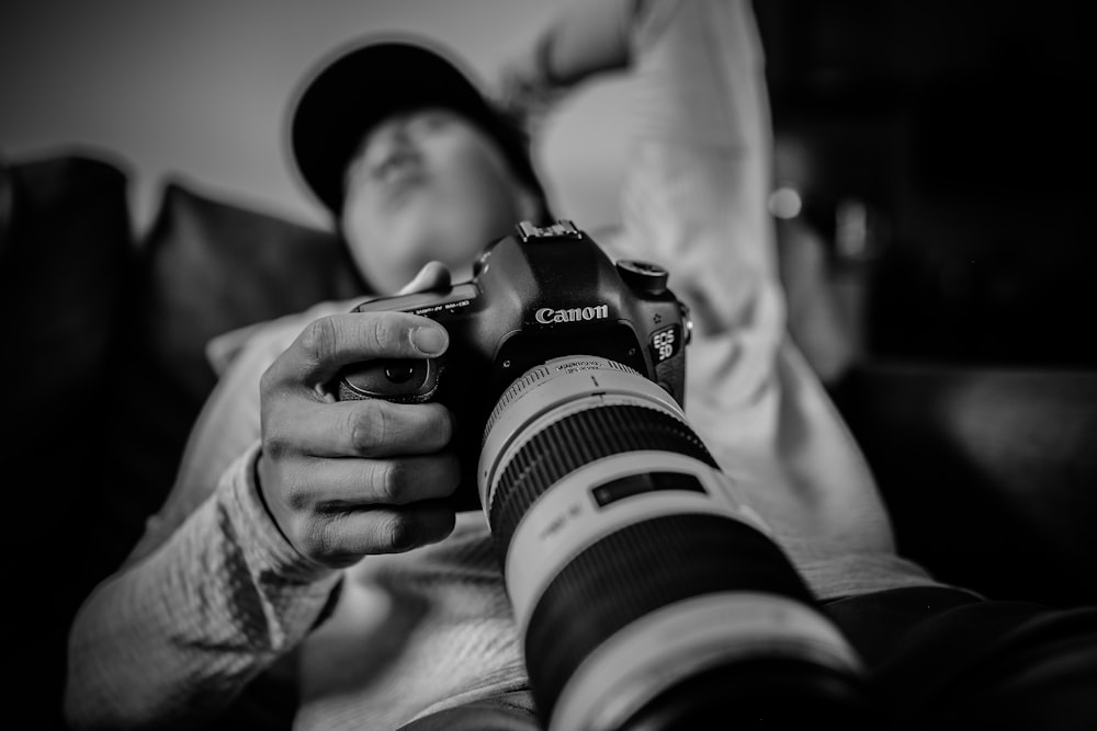 homem segurando Canon DSLR câmera