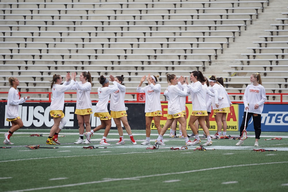 group of woman playing lacrosse on field