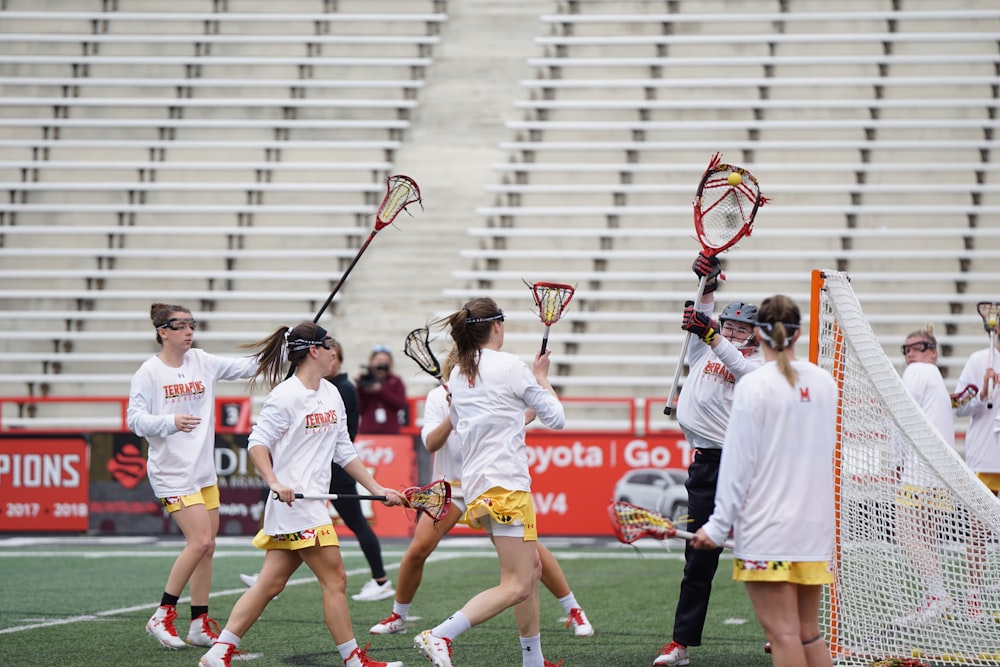 group of people playing lacrosse on field