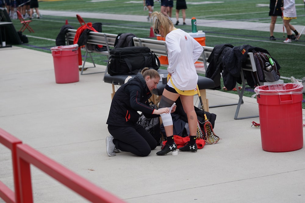 woman taping knee of woman